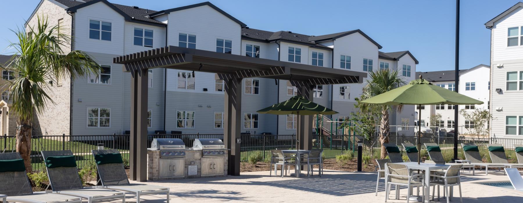 a pool with chairs and umbrellas by a building