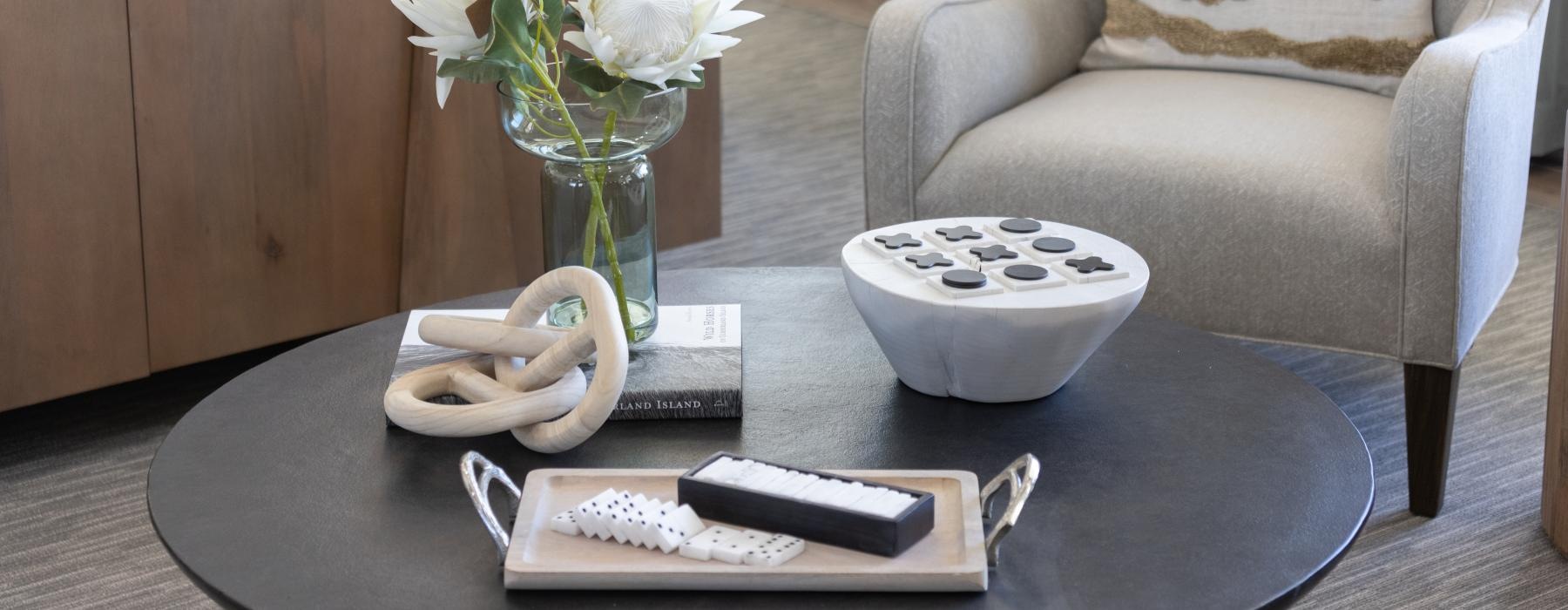a coffee table with a vase of flowers and a remote control