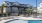a pool with chairs and umbrellas by a building