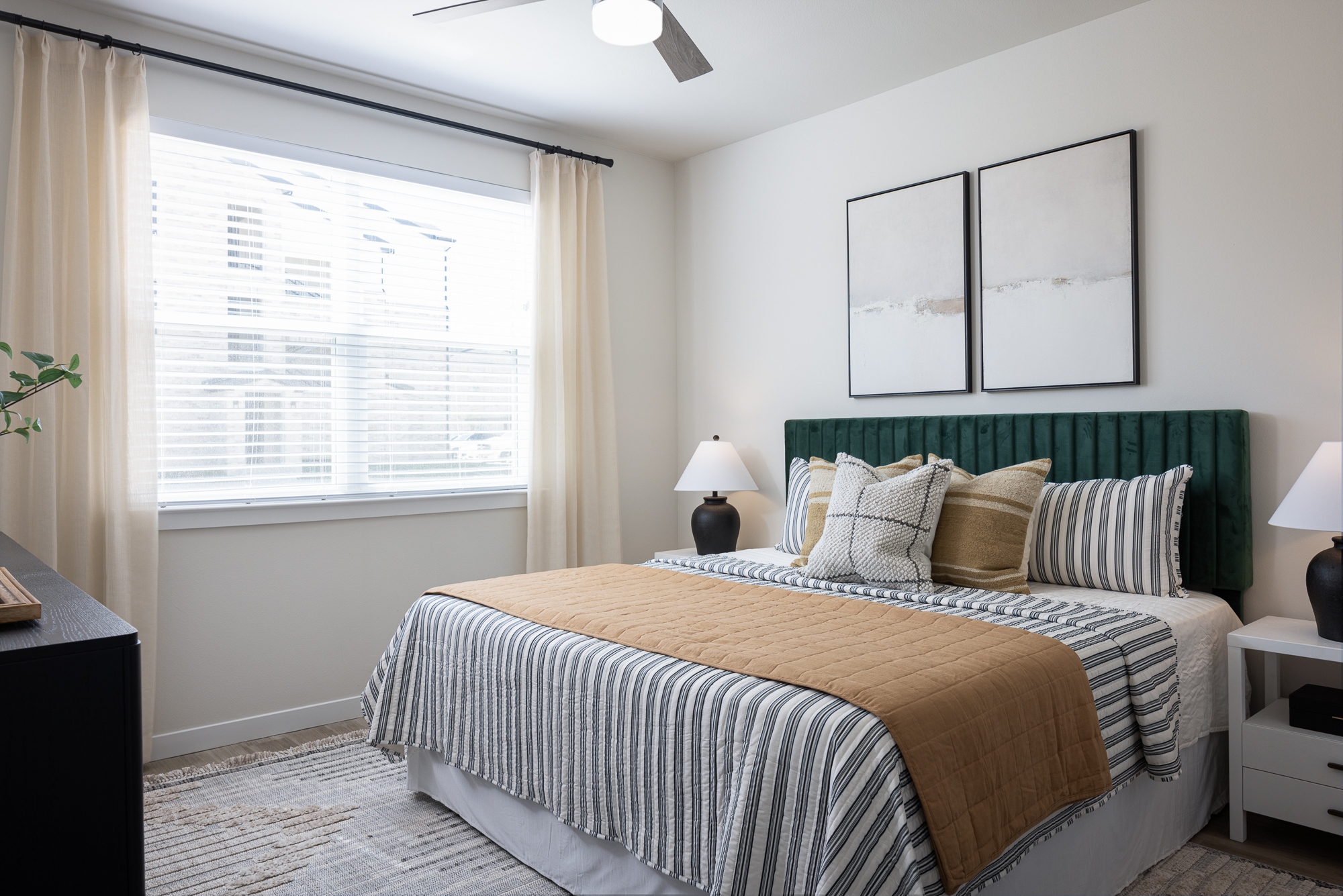 bed in bedroom with green headboard with a large bright window in Marble Falls, TX.