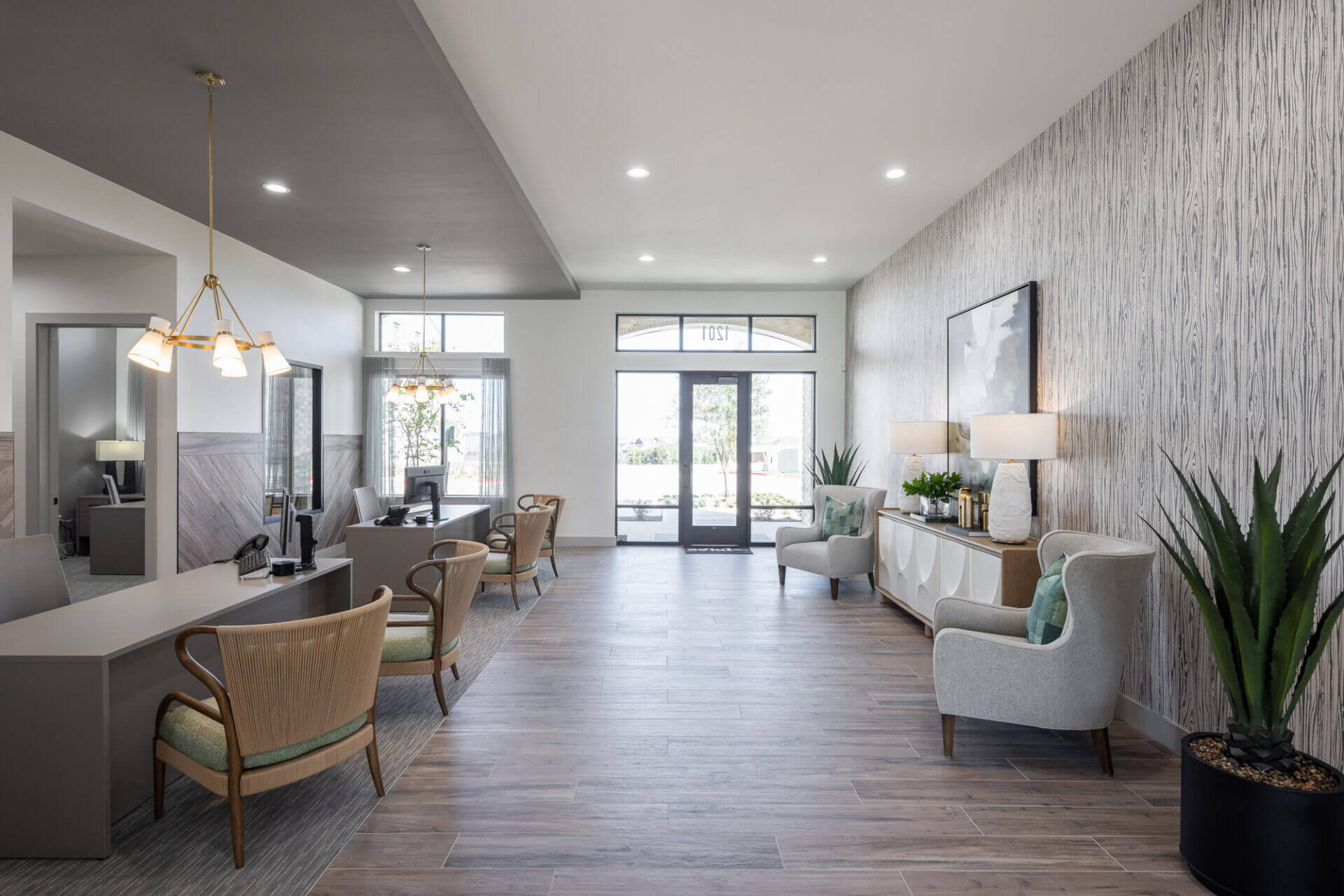 Modern office and meeting space with two desks, wooden chairs, and decorative wall art.