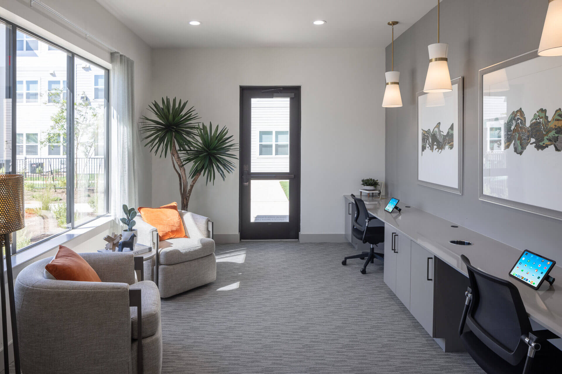 coworking room with two desk spots and two sofa chairs with a large window allowing a lot of bright natual light at prose thunder rock in marble falls, tx