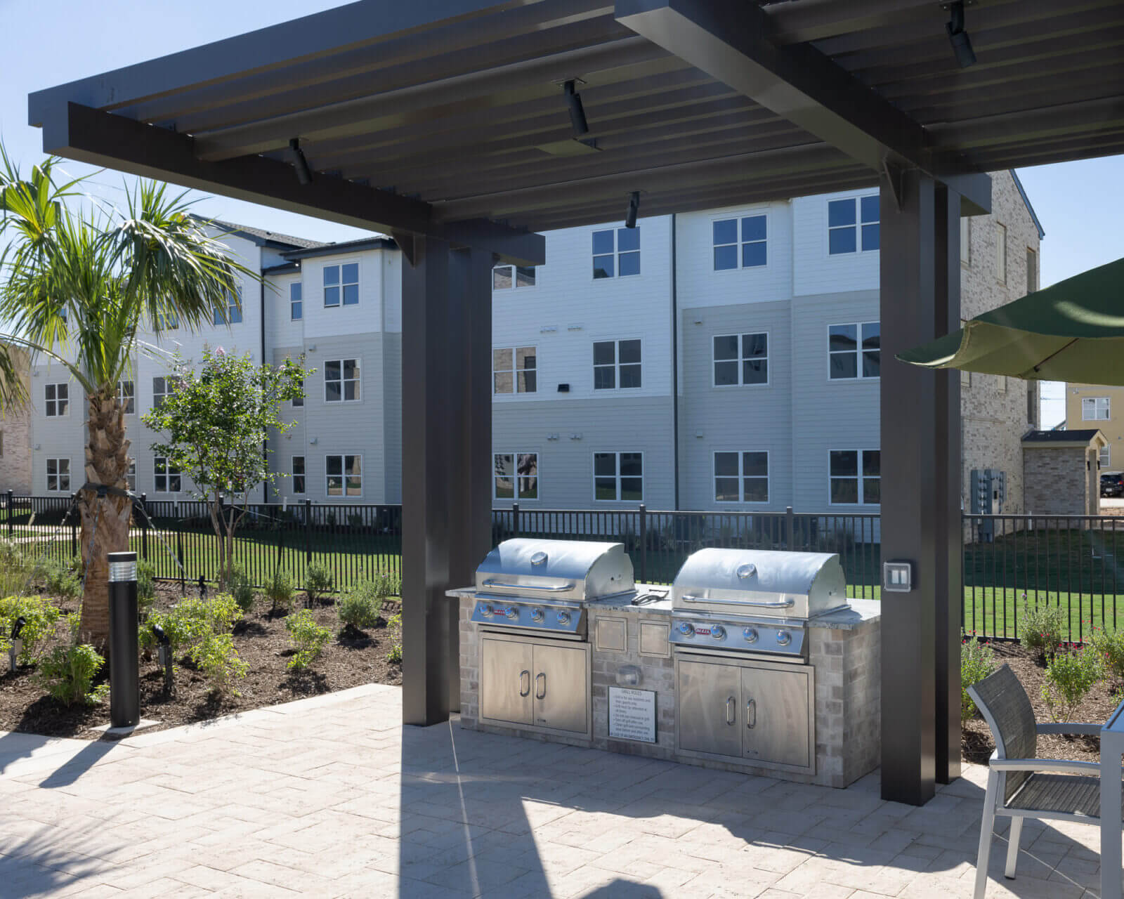 A patio featuring a grill and a dining table, perfect for outdoor cooking and gatherings.