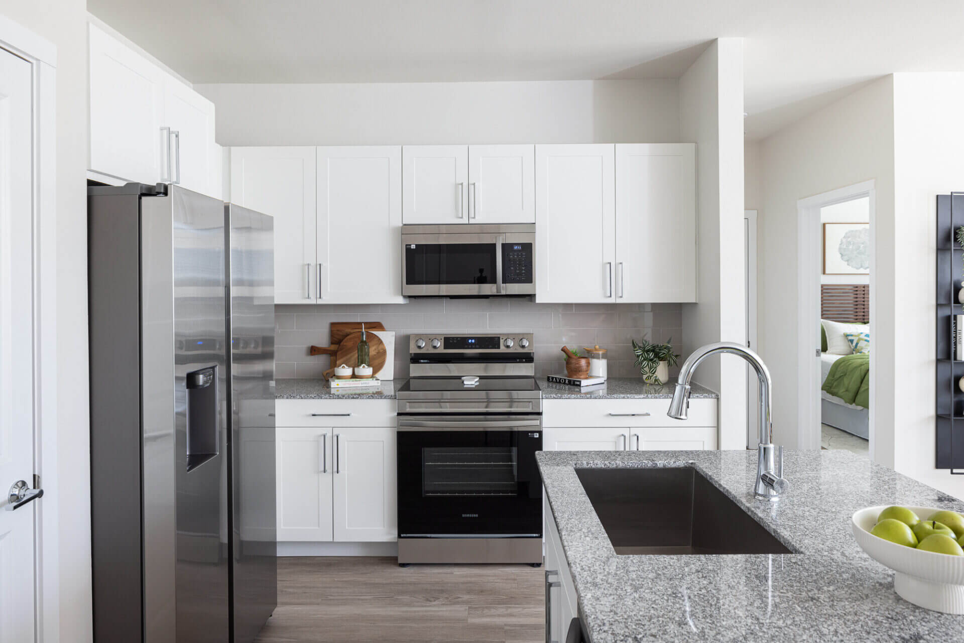 Kitchen with granite counters, silver appliances, white cabinetry in marble falls, tx